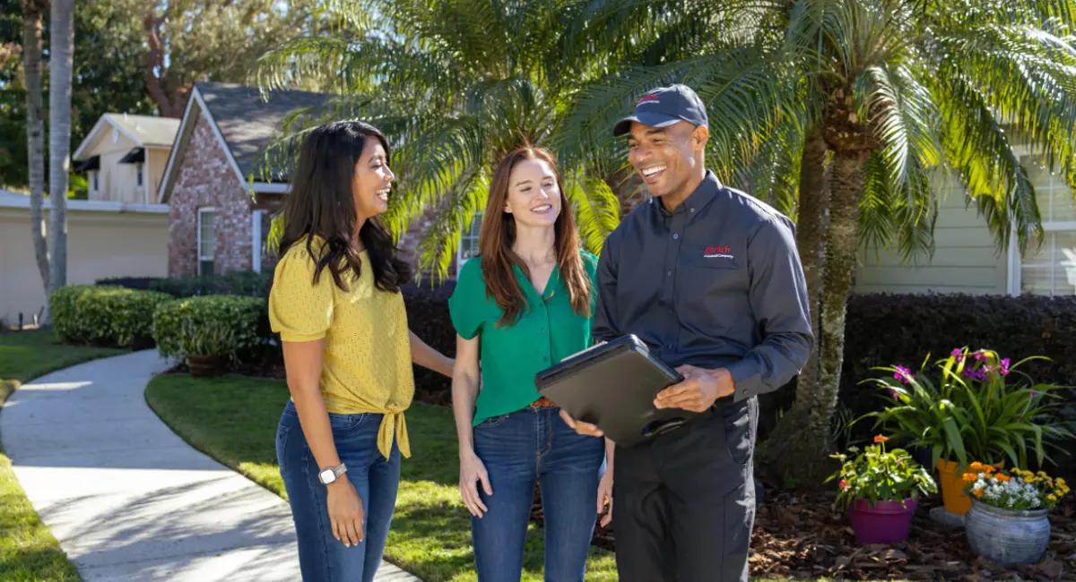 Ehrlich technician with clients outside of a home