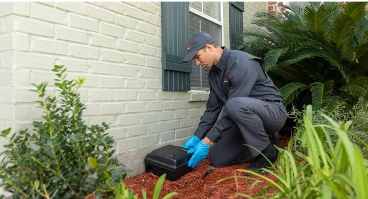 An Ehrlich Pest Control technician sets a rodent bait box