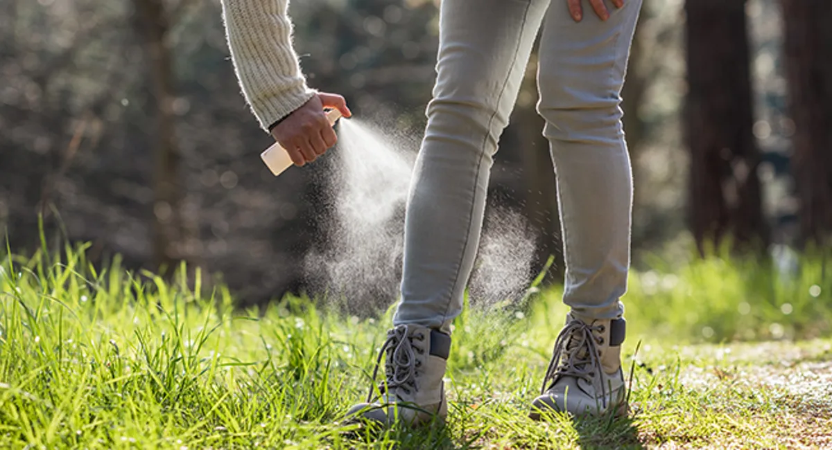 woman applying mosquito repellent