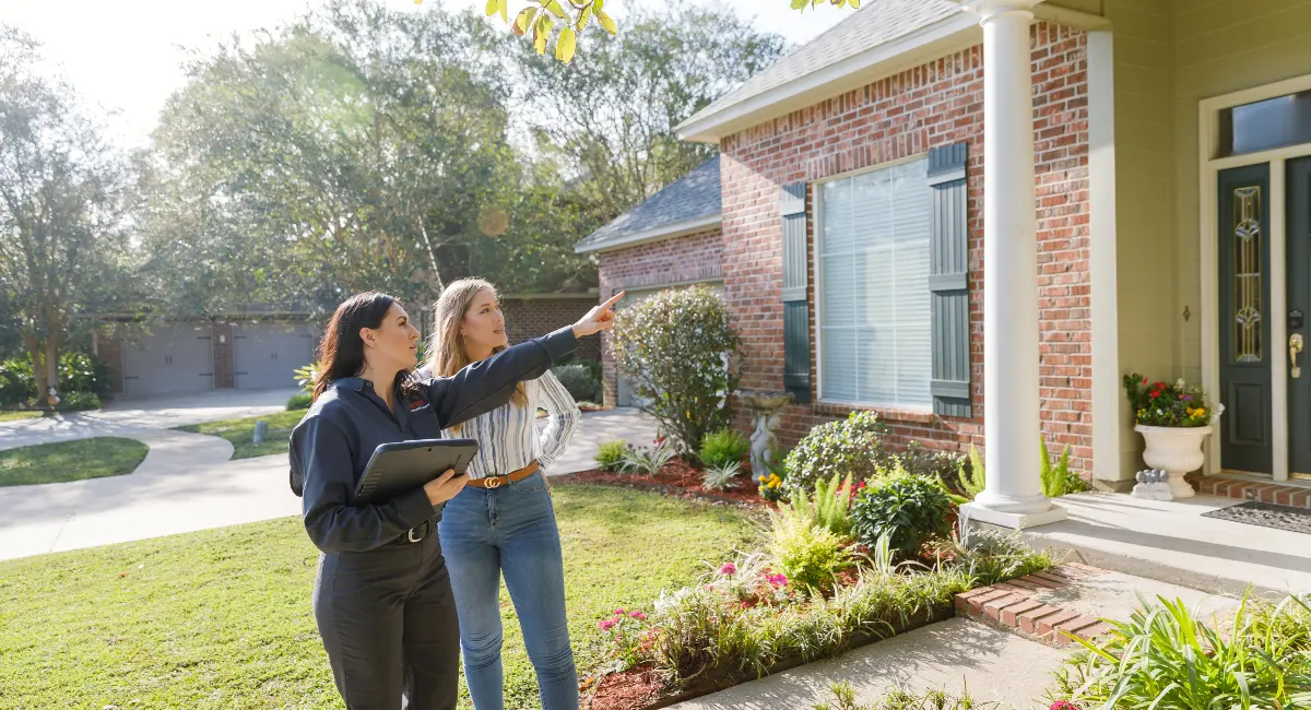 Technician with customer outside house inspecting